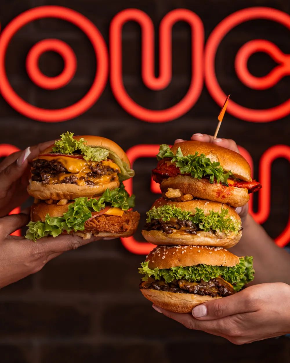 PHAT Buns smash burgers in front of neon signage